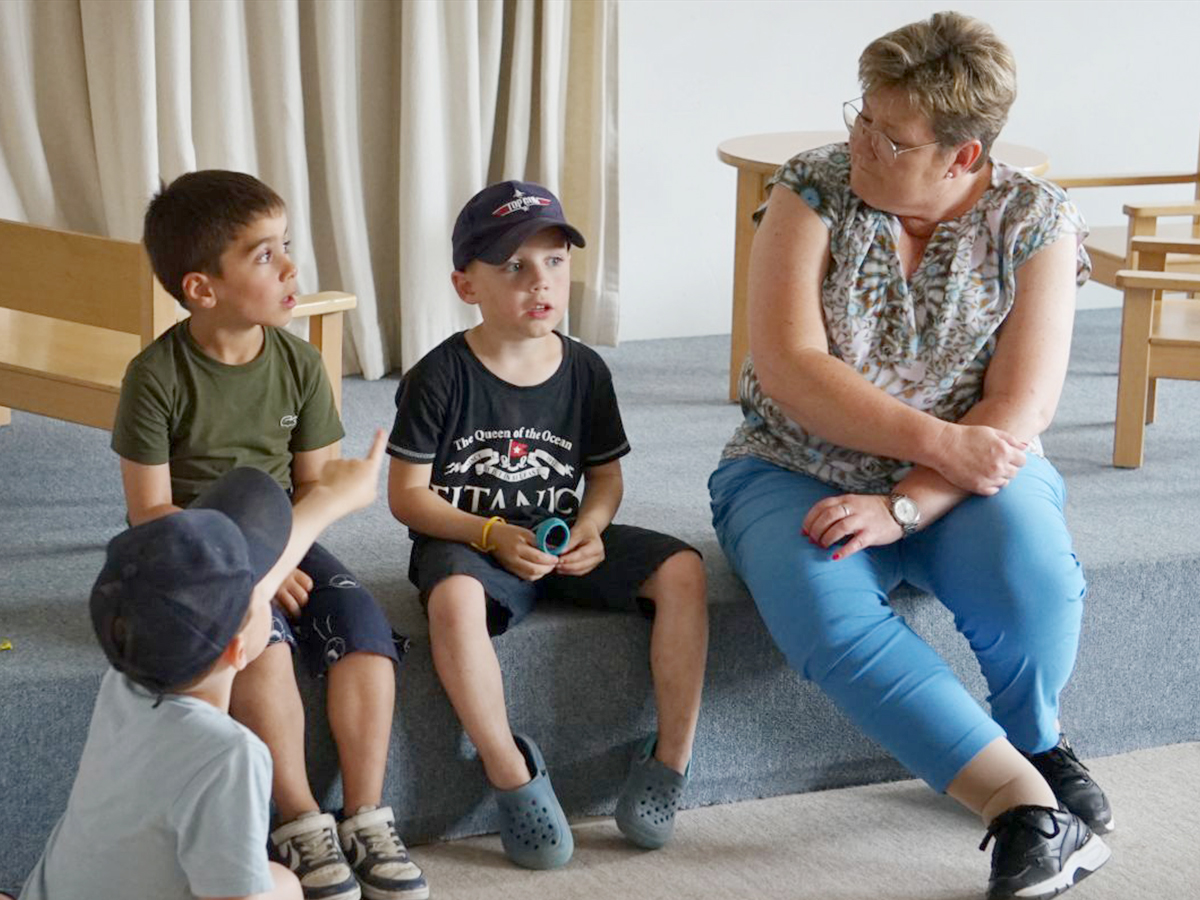 Auf dem Foto sieht man Staatssekretärin Bettina Brück im Gespräch mit Kindern.