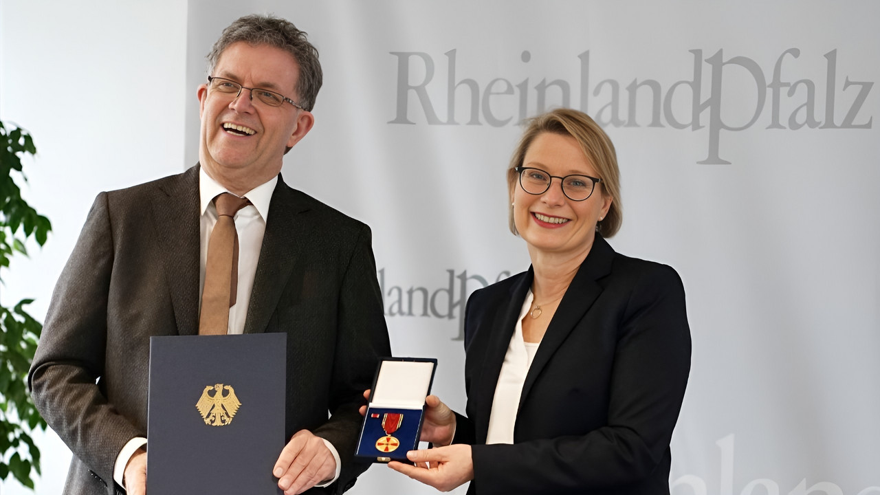 Das Foto zeigt Bildungsministerin Dr. Stefanie Hubig und Ulf Störmer. Er hält seine Urkunde, die Ministerin die Verdienstmedaille in die Kamera. 