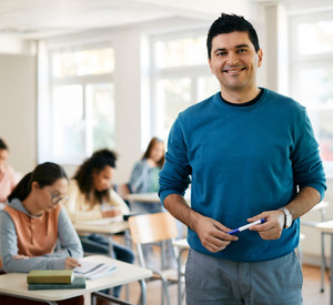 Porträt eines Lehrers während einer Klasse an der High School, der in die Kamera schaut.