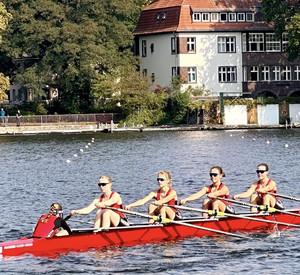 Auf dem Foto sind die Mädchen des Ruderteams zu sehen. Sie Rudern gemeinsam. 