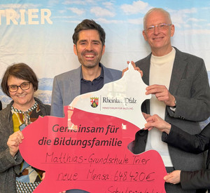 Förderbescheidübergabe in Trier Bildungsminister Sven Teuber übergibt Triers Oberbürgermeister Wolfram Leibe und weiteren Personen einen Förderbescheid.