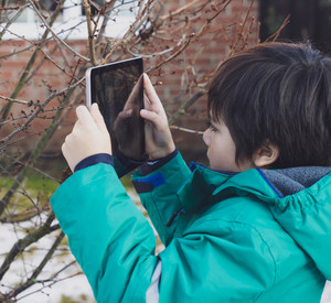 ein Junge fotografiert mit einem Tablet 