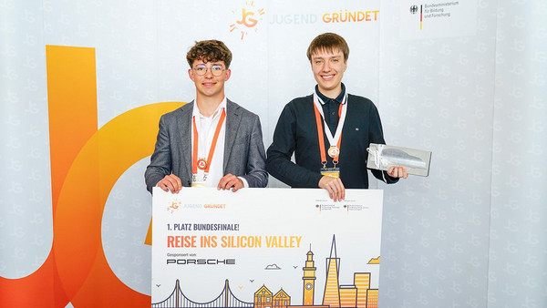 Paul Scherer und Paul Flad halten einen großen Gutschein (Reise ins Silicon Valley) in die Kamera