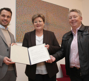 Das Foto zeigt die Bescheidübergabe in Koblenz. Zu sehen sind von links nach rechts: Oberbürgermeister David Langner, Bildungsstaatsekretärin Bettina Brück und Bürgermeisterin Ulrike Mohrs