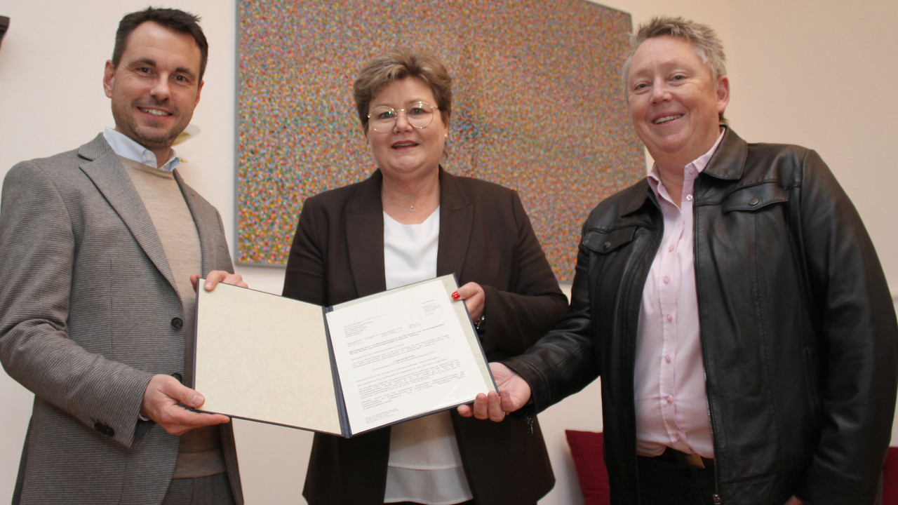 Das Foto zeigt die Bescheidübergabe in Koblenz. Zu sehen sind von links nach rechts: Oberbürgermeister David Langner, Bildungsstaatsekretärin Bettina Brück und Bürgermeisterin Ulrike Mohrs