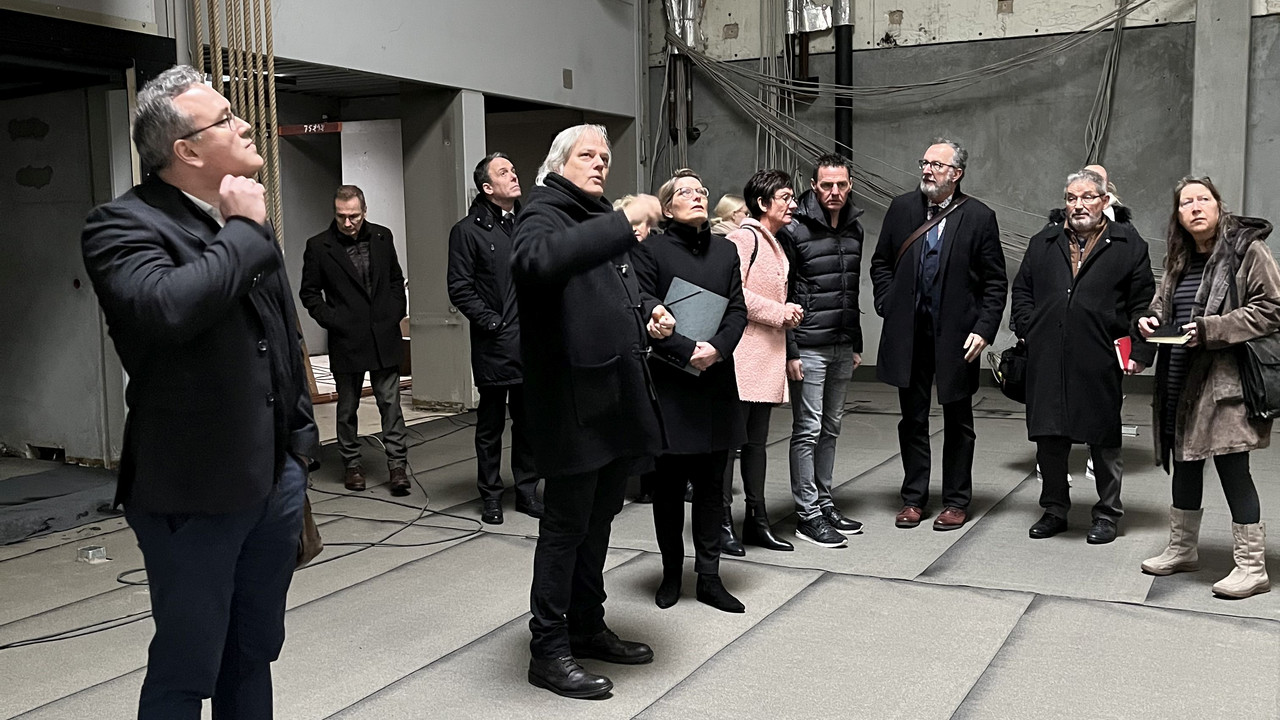 Das Foto zeigt Ministerin Hubig im Gespräch mit Schulleiter Dr.Braner während eines Rundgangs durch die Sporthalle des Rhein-Gymnasiums. Im Hintergrund sind weitere Beteiligte zu sehen. 