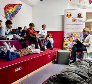 Zu sehen ist Bildungsministerin Hubig, die den Jungs vorliest. 