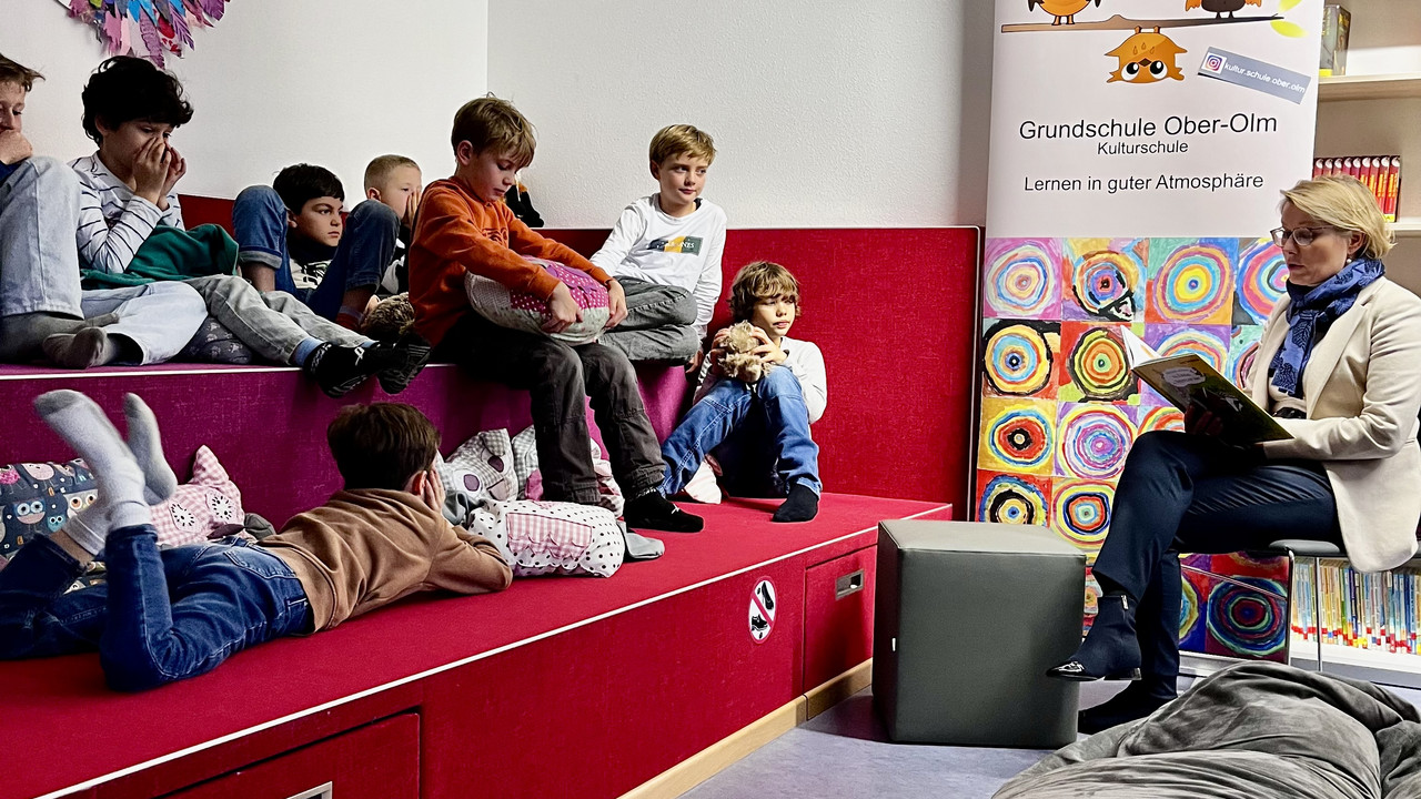 Zu sehen ist Bildungsministerin Hubig, die den Jungs vorliest. 
