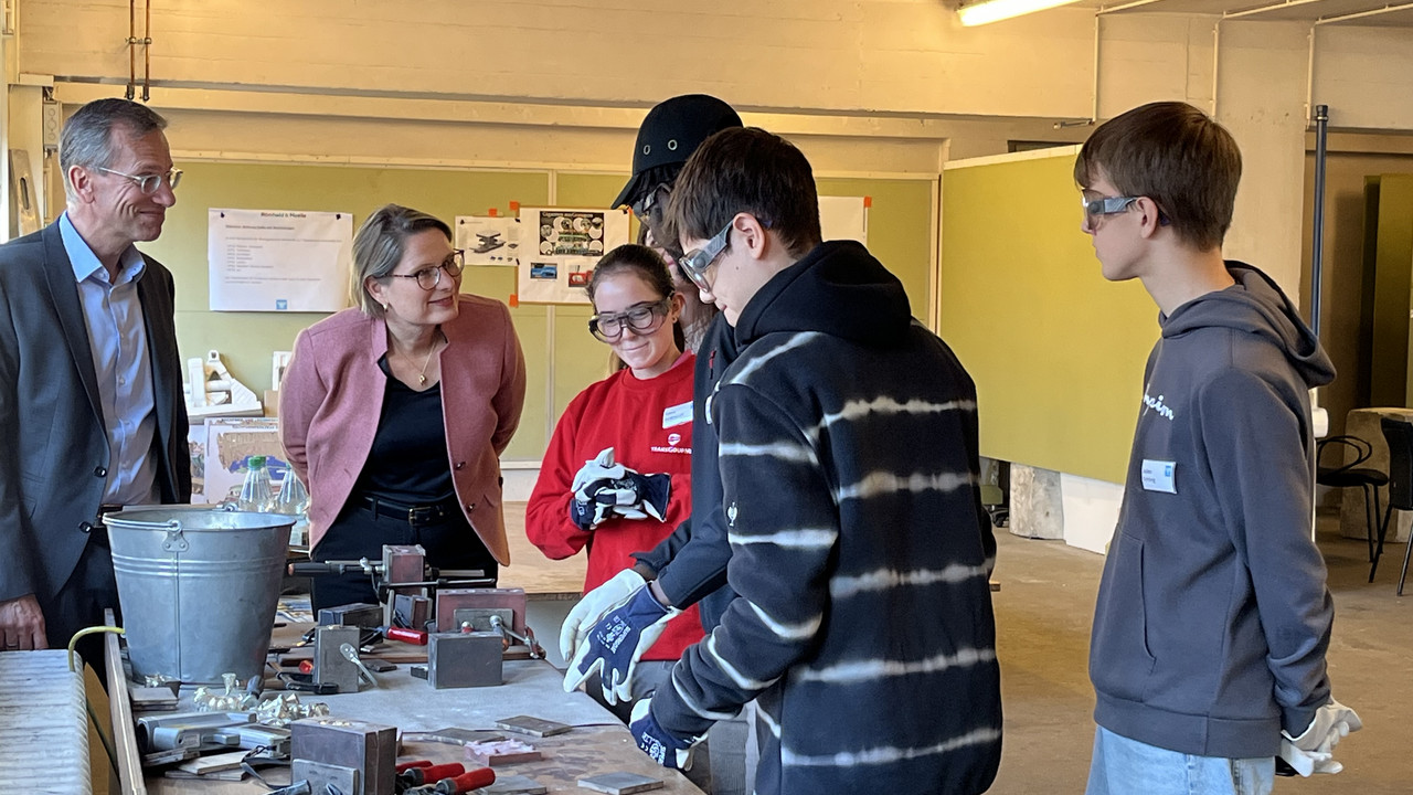 Auf dem Foto sehen Sie Bildungsministerin Dr. Stefanie Hubig. Sie schaut sich die Arbeit von Praktikantinnen und Praktikanten bei Römheld & Moelle an. 