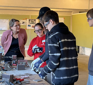 Auf dem Foto sehen Sie Bildungsministerin Dr. Stefanie Hubig. Sie schaut sich die Arbeit von Praktikantinnen und Praktikanten bei Römheld & Moelle an. 