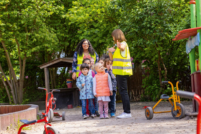 Kinder mit Erziehern auf dem Spielplatz