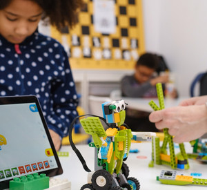 Kinder, die mithilfe eines Tablets einen Roboter zusammenbauen.